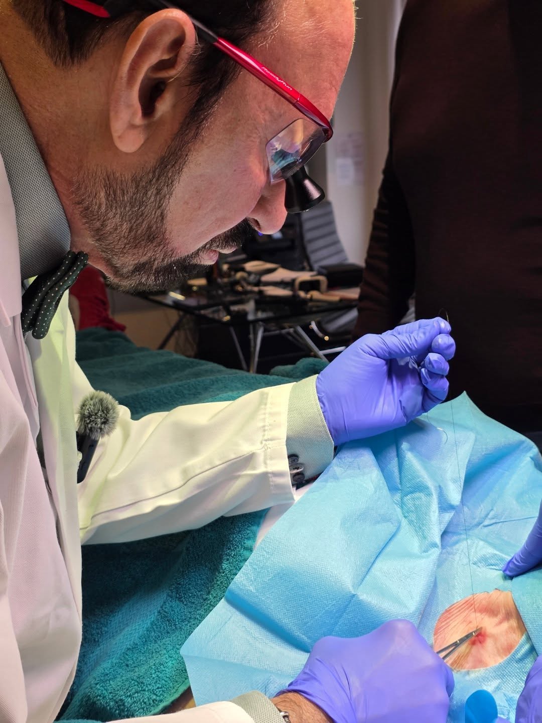 Dr Masani carrying out excision and suturing following punch biopsy for suspected Squamous Cell Carcinoma (SCC). Early d